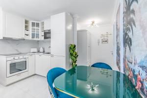 uma cozinha com uma mesa azul e cadeiras azuis em Tropical studio with a balcony - Lake View em Territet