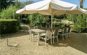 a wooden table and chairs under an umbrella at Logis De Chenevière in Juignac