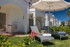 dwa krzesła i parasol na podwórku domu w obiekcie Garden Saladina - Adults Only w Playa de Muro