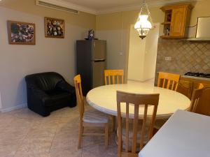 een keuken met een tafel en stoelen en een koelkast bij Luxurious house at Coromandel in La Rotraite