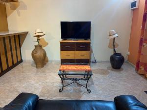 a living room with a couch and a tv on a dresser at Luxurious house at Coromandel in La Rotraite