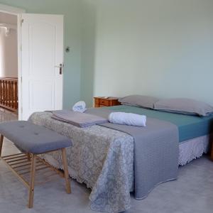 a bedroom with two beds and a chair at Villa Costa in Periyiálion
