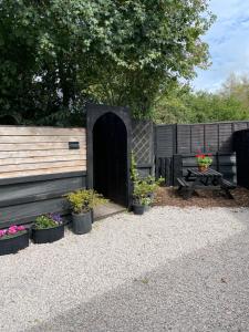 a garden with a black gate and some plants at THE LITTLE NEST BEACH sole use accommodation near to bath in Wick