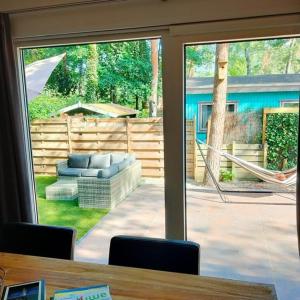 una puerta corredera de cristal con vistas al patio en Chalet Hoenderloo, en Hoenderloo