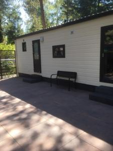 a bench sitting in front of a building at Chalet Hoenderloo in Hoenderloo