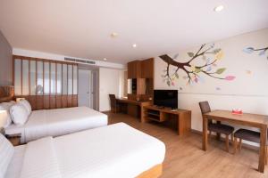 a hotel room with two beds and a desk at Areca Lodge in Pattaya +60 photos