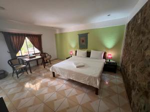 a bedroom with a large bed and a table with a desk at Alona Swiss Resort in Panglao Island