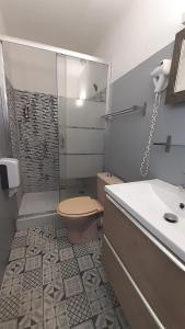 a bathroom with a shower and a toilet and a sink at Logis Hôtel Restaurant Le 1050 in Saint-Agrève
