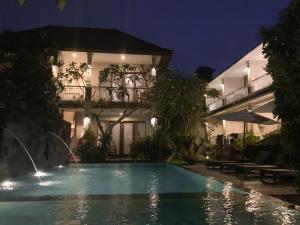 a swimming pool in front of a house at night at Merthayasa Bungalow 2 in Ubud