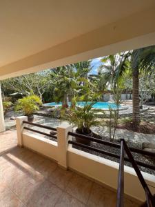 einen Balkon mit Blick auf den Pool und die Palmen in der Unterkunft Alona Swiss Resort in Panglao