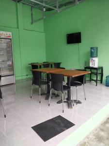 a table and chairs in a room with a green wall at Omah 365 Homestay in Sentool