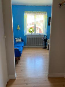 een blauwe kamer met een bank en een raam bij Skogshemmet in Ludvika