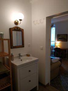 ein Badezimmer mit einem Waschbecken, einem Spiegel und einem Sofa in der Unterkunft Le Voltaire in Souppes-sur-Loing