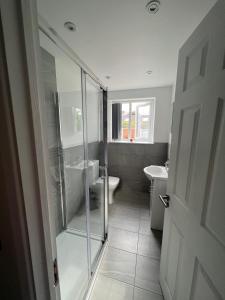 a bathroom with a shower and a toilet and a sink at Luxury 2 bedroom apartment near the O2 and Canary Wharf in Eltham