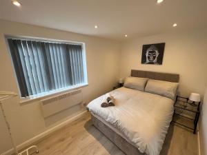 a bedroom with a bed with a skull picture on the wall at Luxury 2 bedroom apartment near the O2 and Canary Wharf in Eltham