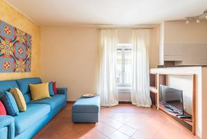 ein Wohnzimmer mit einem blauen Sofa und einem TV in der Unterkunft Design Apartments Florence Combo in Florenz