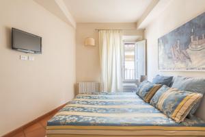 Schlafzimmer mit einem Bett und einem TV an der Wand in der Unterkunft Design Apartments Florence Combo in Florenz