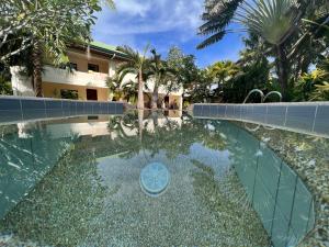 een zwembad voor een gebouw met palmbomen bij Alona Swiss Resort in Panglao