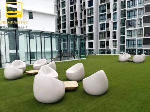 un groupe de chaises blanches assises sur l'herbe d'un bâtiment dans l'établissement H2O Retreat Studio Home 5min to LRT by Premium Stay, à Petaling Jaya