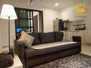 - un canapé brun dans le salon avec cuisine dans l'établissement H2O Retreat Studio Home 5min to LRT by Premium Stay, à Petaling Jaya