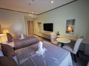 ein Hotelzimmer mit zwei Betten und einem Fernseher in der Unterkunft Yes Hotel Pandi Bulacan in Pandi + 41 Fotos