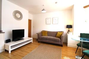 ein Wohnzimmer mit einem Sofa und einem TV in der Unterkunft Corbiere House @ Short Stays in Basingstoke