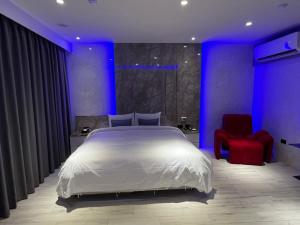 ein Schlafzimmer mit einem weißen Bett und einem roten Stuhl in der Unterkunft MY Motel in Mingjian