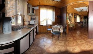 a kitchen with a counter and a table with chairs at Kovcheg Holiday Home in Mykulychyn