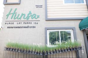 a sign on the side of a building with tall grass at หรรษาเพลส ลาดพร้าว 124 in Ban Bang Toei (1)