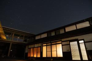 un edificio con finestra illuminata di notte di 古民家柚子季 a Tonami