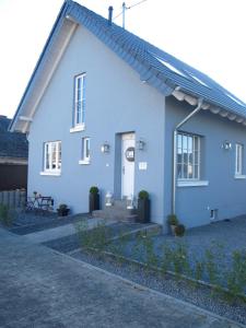 a blue house with a white door and a porch at Pension Willebuhr in Mayen