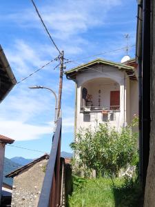ein Gebäude mit einem Balkon mit einer Person darauf in der Unterkunft A new path to the waterfall in Abbadia Lariana