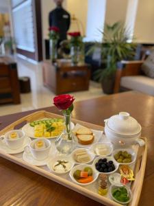 a tray with food on a table with a rose at Toot house elwsam in Taif