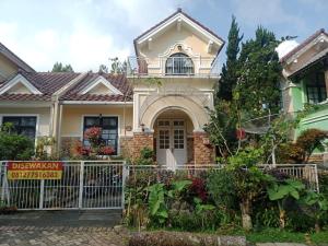 a house with a sign in front of it at Villa kota bunga cipanas 3 kamar baru in Cikundul