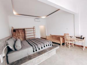 1 dormitorio con 1 cama grande y escritorio en Sanctum Hotel and Dive- Nusa Penida, en Nusa Penida