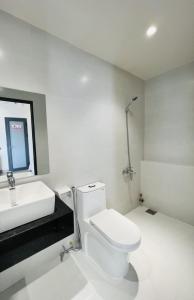 ein Badezimmer mit einem weißen WC und einem Waschbecken in der Unterkunft MIDMOST HOUSE in Cần Thơ