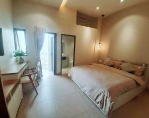 a bedroom with a large bed and a desk at MIDMOST HOUSE in Can Tho