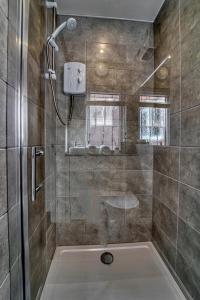a bathroom with a shower with a glass door at Guest Homes - Taylor Apartment in Worcester