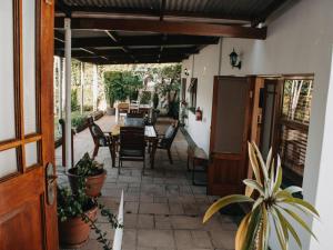 eine Terrasse mit einem Tisch und Stühlen sowie ein Haus in der Unterkunft Cummings Guesthouse in Wellington