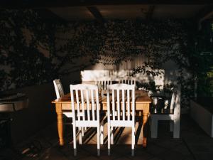 ウェリントンにあるCummings Guesthouseのダイニングルームテーブル(白い椅子3脚付)