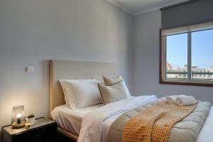 een slaapkamer met een groot bed en een raam bij Forum Escape, a Home in Madeira in Funchal