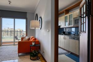 een woonkamer met een bank en een keuken bij Forum Escape, a Home in Madeira in Funchal