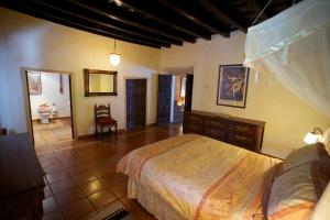 a bedroom with a large bed and a bathroom at Casa Estrella in Alájar