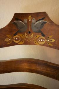 a wooden head board with birds on it at Casa Estrella in Alájar