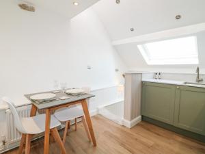 a kitchen with a table and chairs and a window at The Hayloft in Matlock