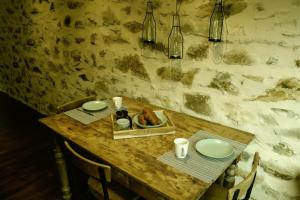 una mesa de madera con platos, velas y botellas en L'Atelier - Gîte urbain chaleureux, en Saint-Hubert
