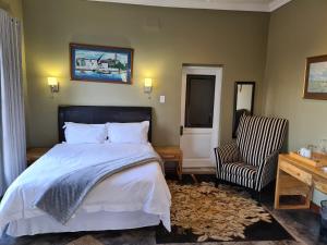 a bedroom with a bed and a desk and a chair at Metsing at Harties in Hartbeespoort