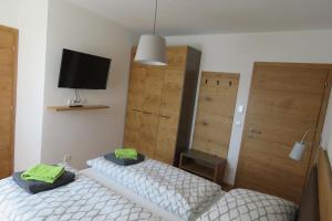 1 dormitorio con 2 camas, TV y puerta en Gasthof Schmidt, 