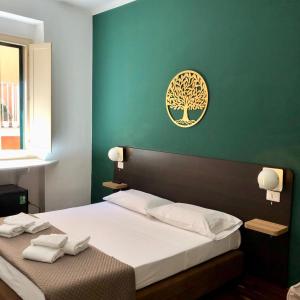 ein Schlafzimmer mit einem Bett mit einem Baumbild an der Wand in der Unterkunft Il Piccolo Albergo Matera in Matera