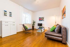 a living room with a couch and a table at Apartments Bensberg in Bergisch Gladbach